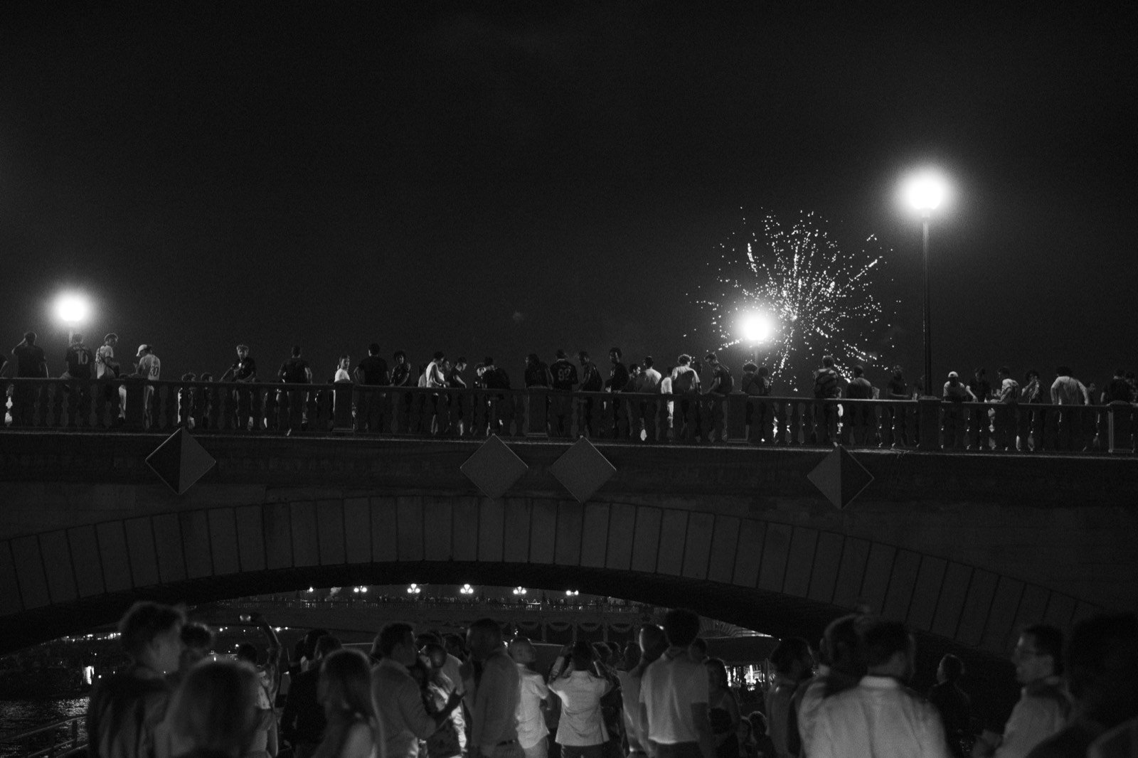 Guests on the yacht deck looking up at fireworks near Pont Alexandre III