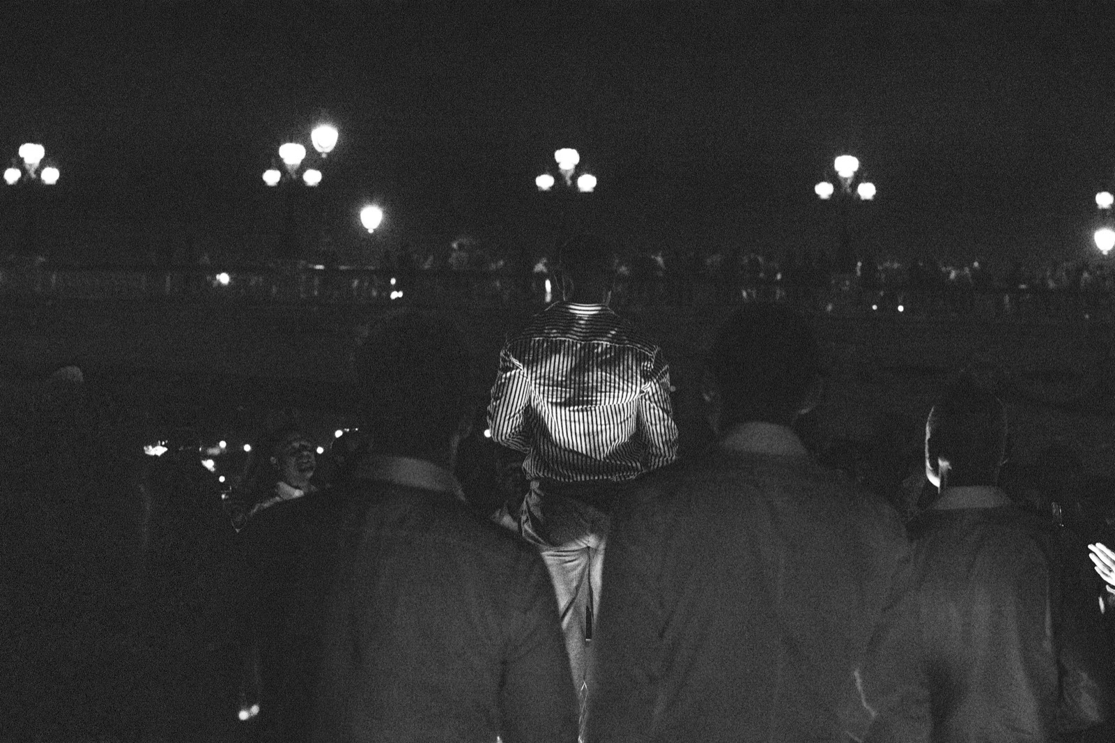 Black and white candid portrait of a guest from behind, amid the crowd